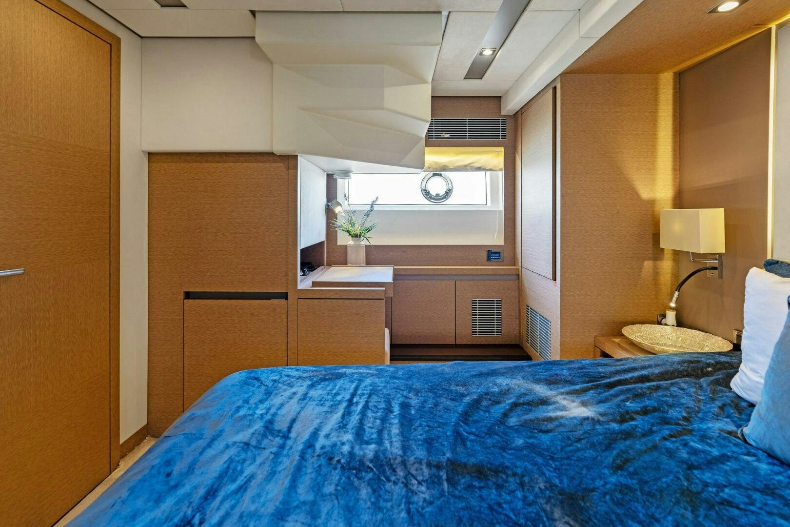 a bedroom with a bed and a lamp aboard PRESTIGE WORLDWIDE Yacht for Sale
