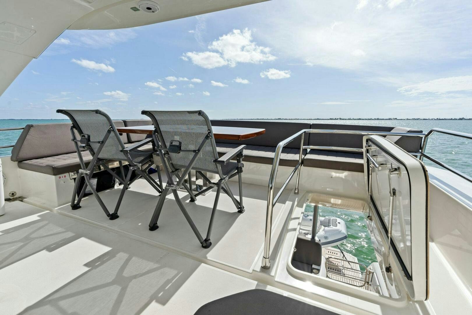 a deck with chairs and a table on it aboard PRESTIGE WORLDWIDE Yacht for Sale