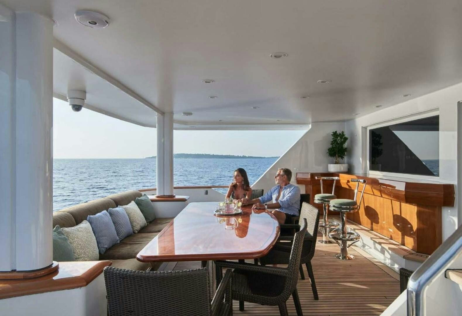 a couple sitting at a table on a boat aboard REARDEN STEEL Yacht for Sale
