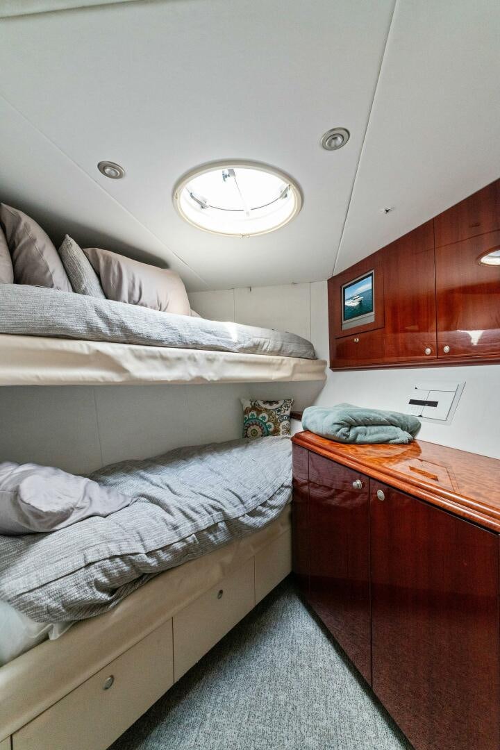 a room with a bed and a desk aboard CORAGGIO Yacht for Sale
