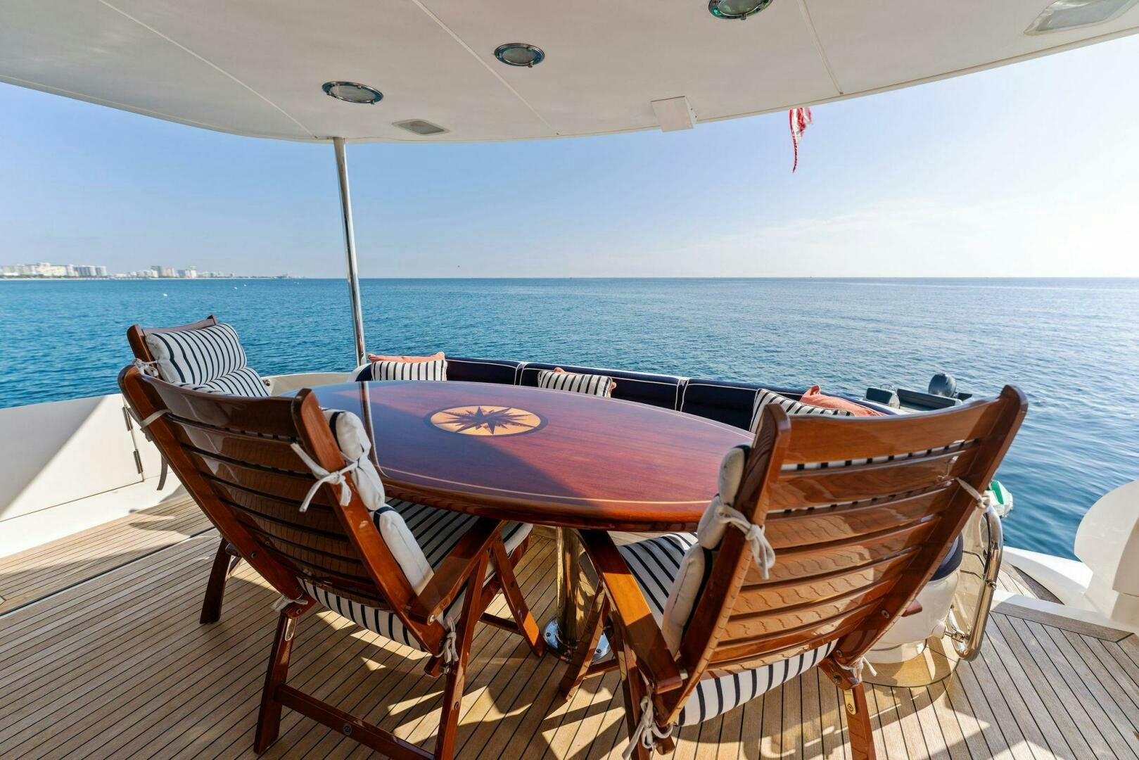 a table and chairs on a deck overlooking a body of water aboard CORAGGIO Yacht for Sale