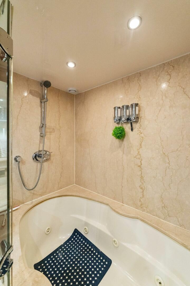a bathroom with a shower and tub aboard CORAGGIO Yacht for Sale