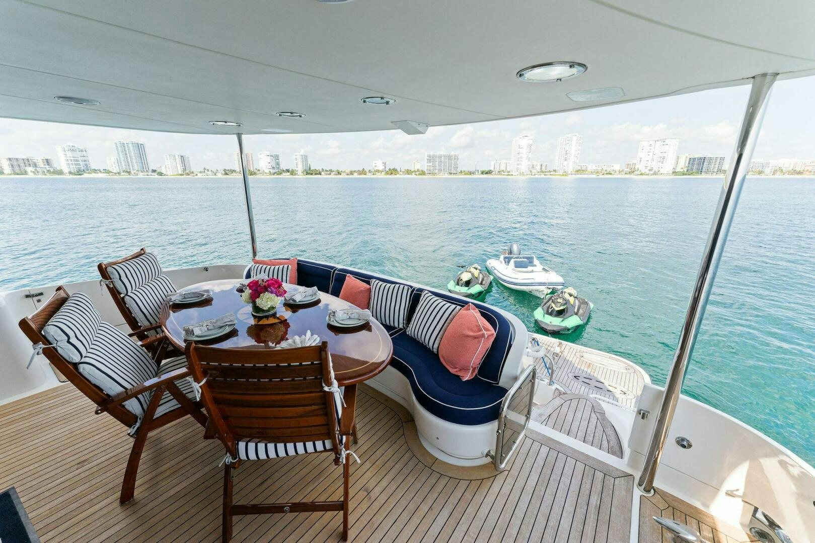 a table set for a meal on a deck overlooking a large body of water aboard CORAGGIO Yacht for Sale