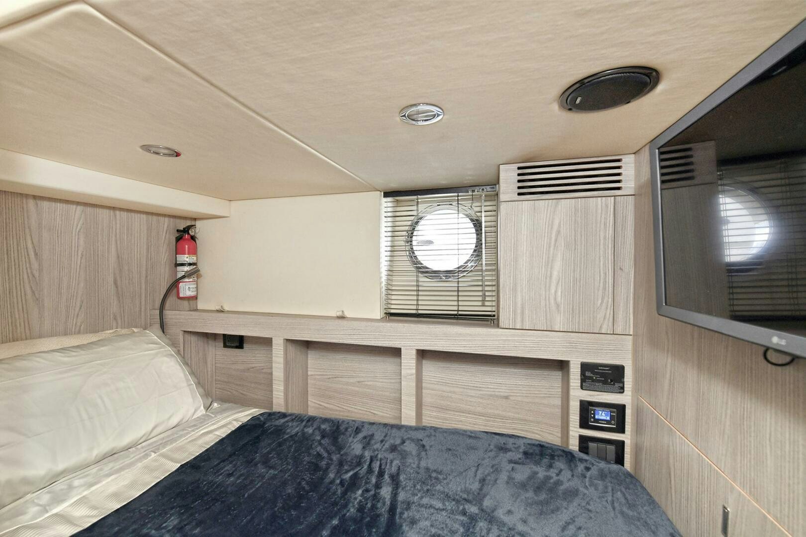 a bed with a window and a mirror above it aboard SLAINTE Yacht for Sale