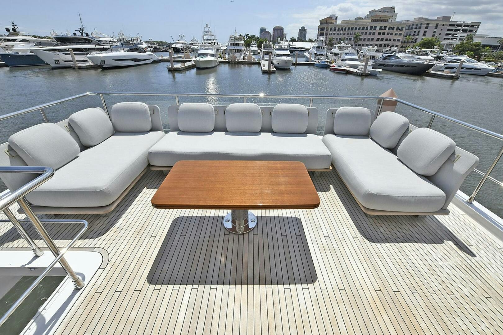 a wooden bench on a deck overlooking a marina with boats aboard SLAINTE Yacht for Sale
