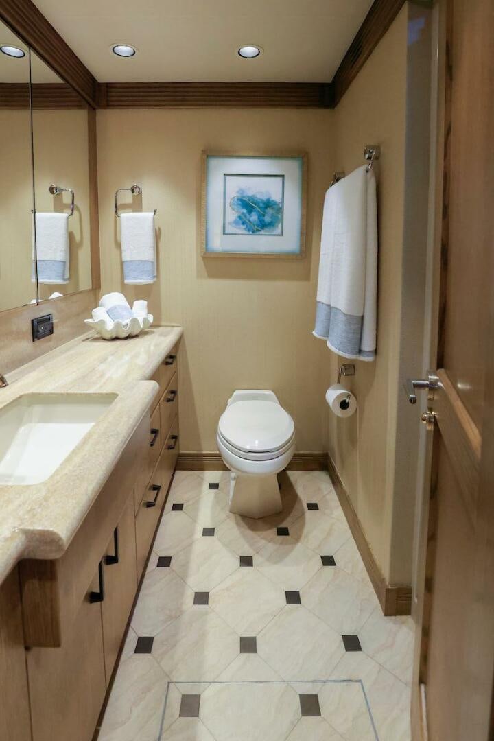 a bathroom with a toilet sink and a mirror aboard NORTH COAST Yacht for Sale