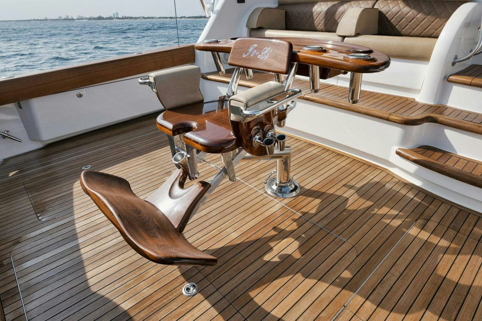 a wooden deck with chairs and a table on it aboard JO-LI Yacht for Sale