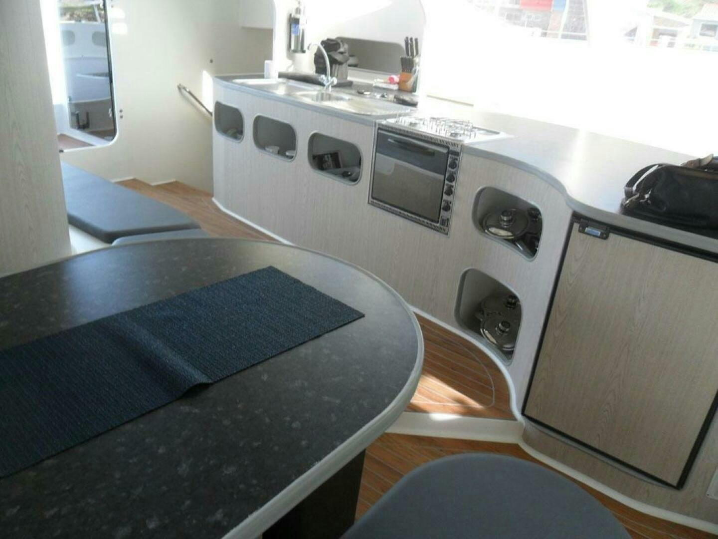 a kitchen with a black table aboard SEA CHANT Yacht for Sale