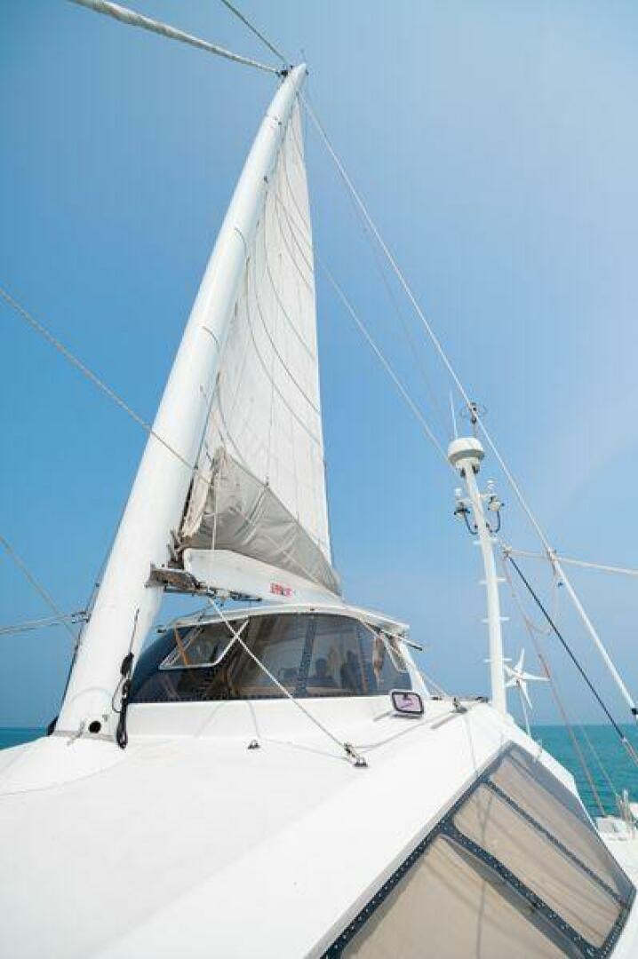 a white sailboat with a white sail aboard SEA CHANT Yacht for Sale