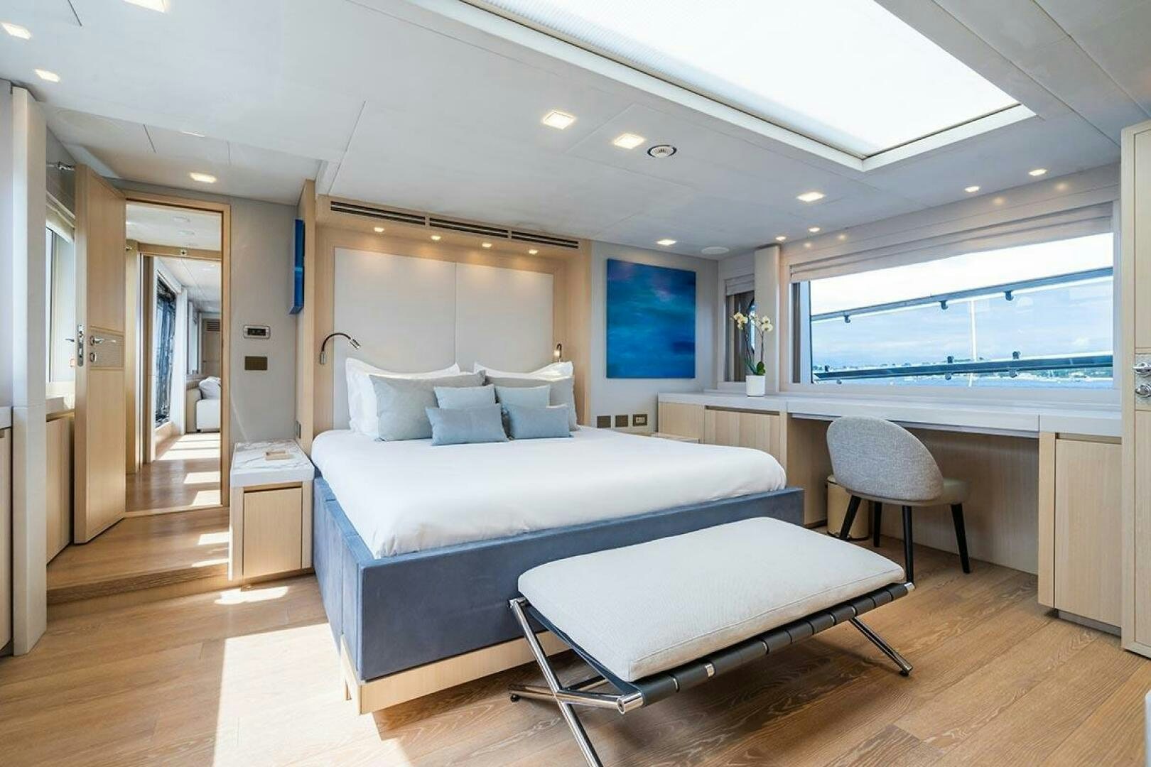 a large bedroom with a bed and a desk aboard ROCCO Yacht for Sale