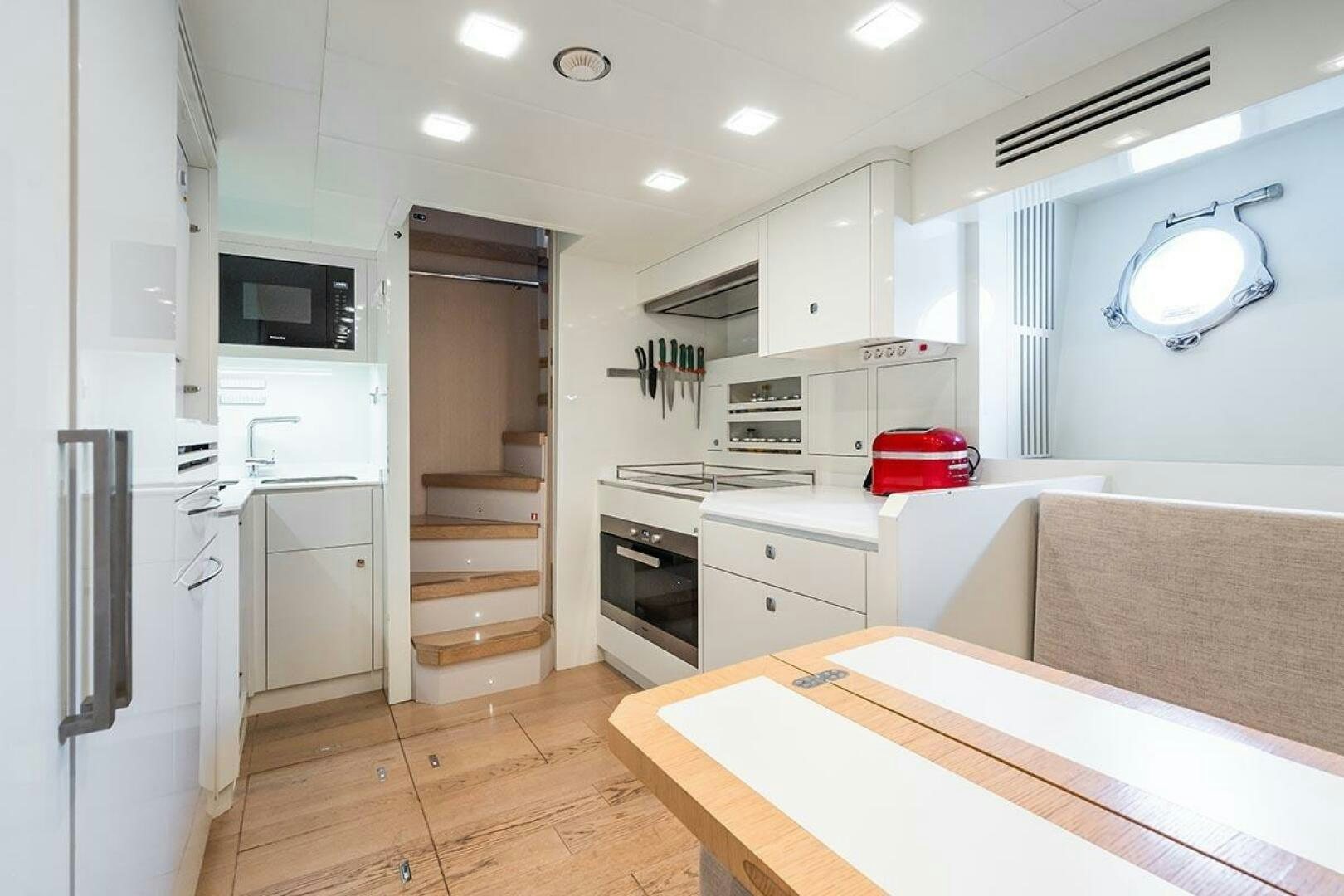 a kitchen with white cabinets aboard ROCCO Yacht for Sale