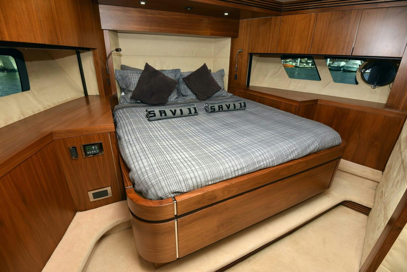 a bed with a white sheet and black and white striped pillow aboard SAVI II  Yacht for Sale