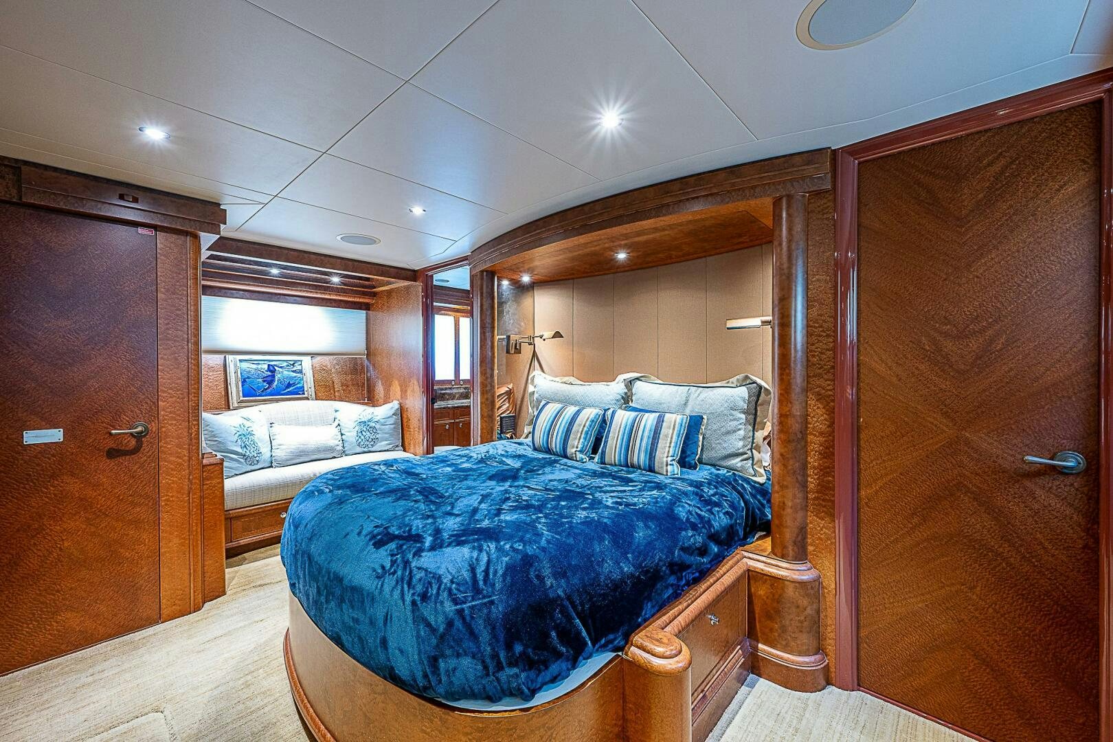 a bedroom with a bed and a wood door aboard PREDATOR Yacht for Sale