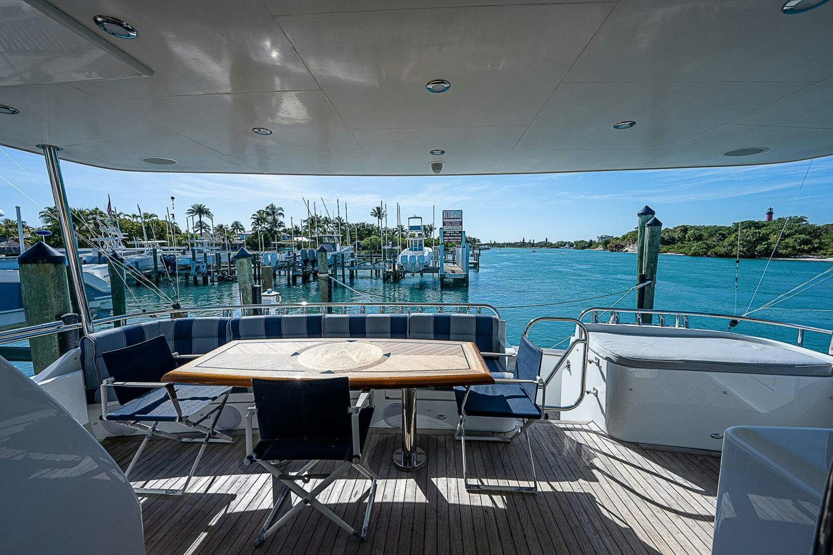 a table and chairs on a deck overlooking a body of water aboard PREDATOR Yacht for Sale