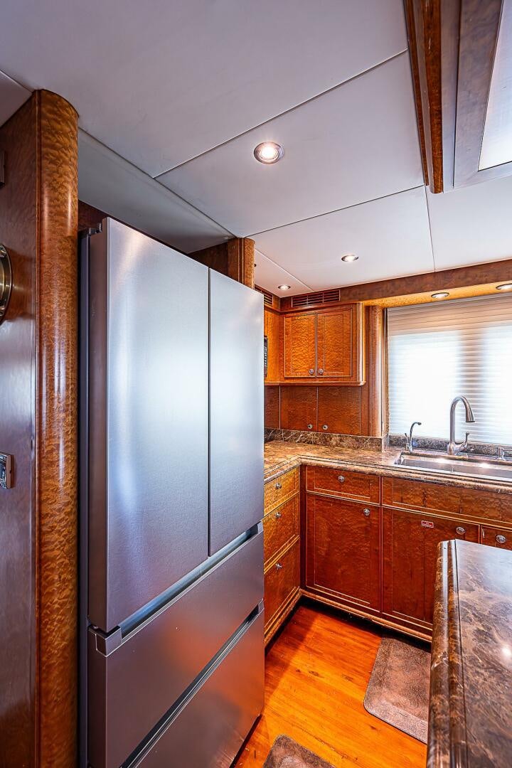 a kitchen with a stainless steel refrigerator aboard PREDATOR Yacht for Sale