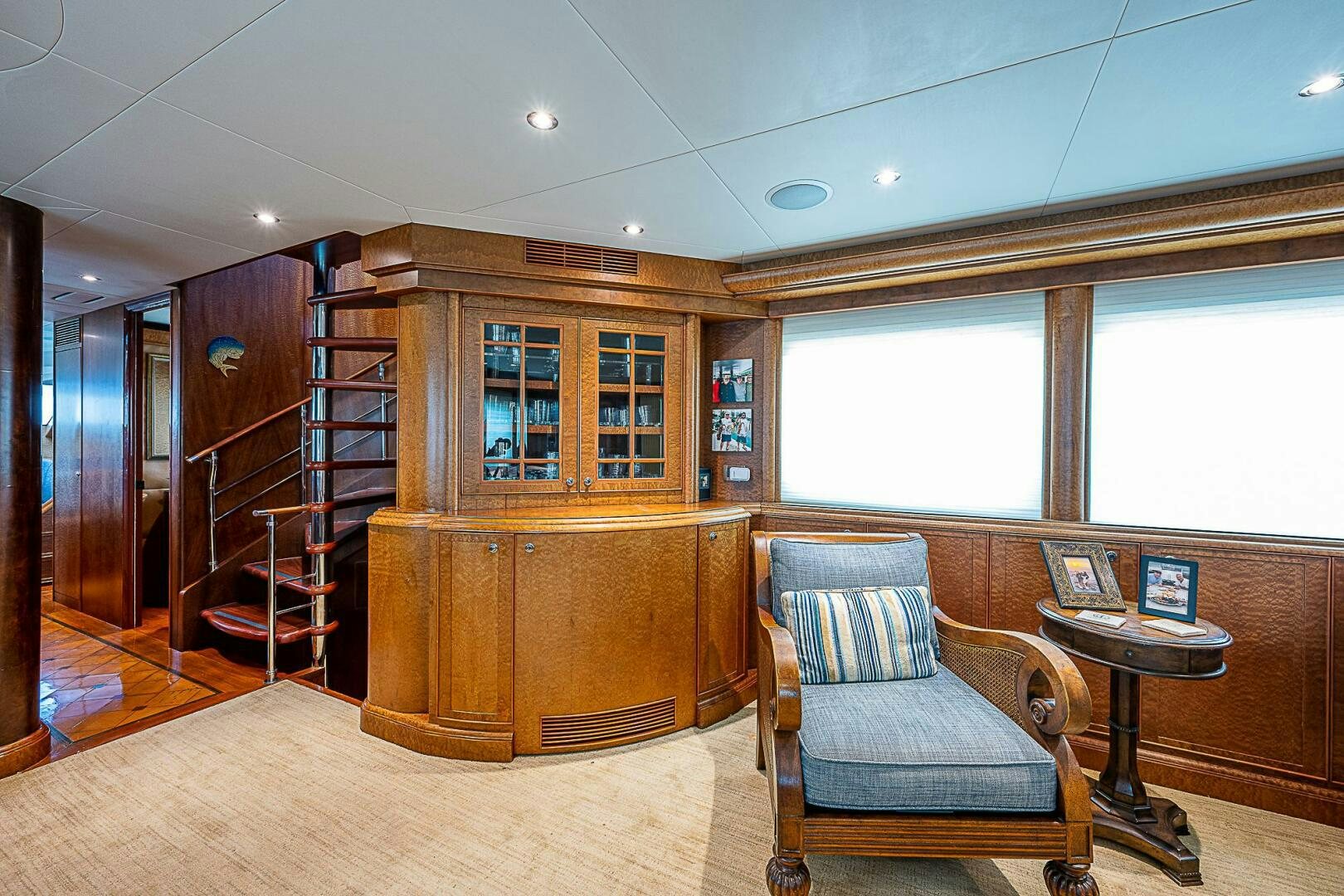 a room with a chair and a table and a bookcase aboard PREDATOR Yacht for Sale