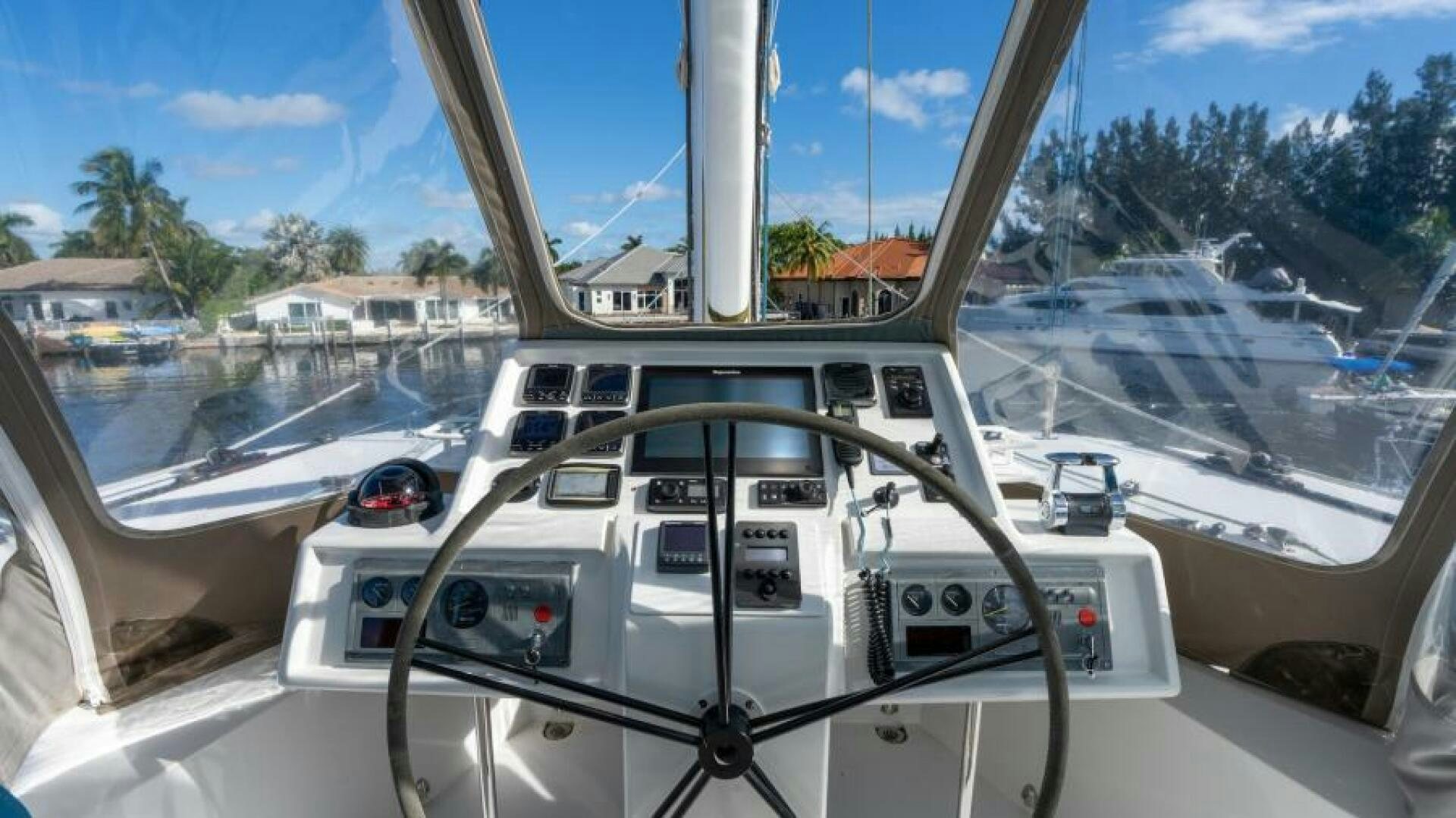 a view of a car on a road with trees and buildings in the background aboard WILDBERRY Yacht for Sale