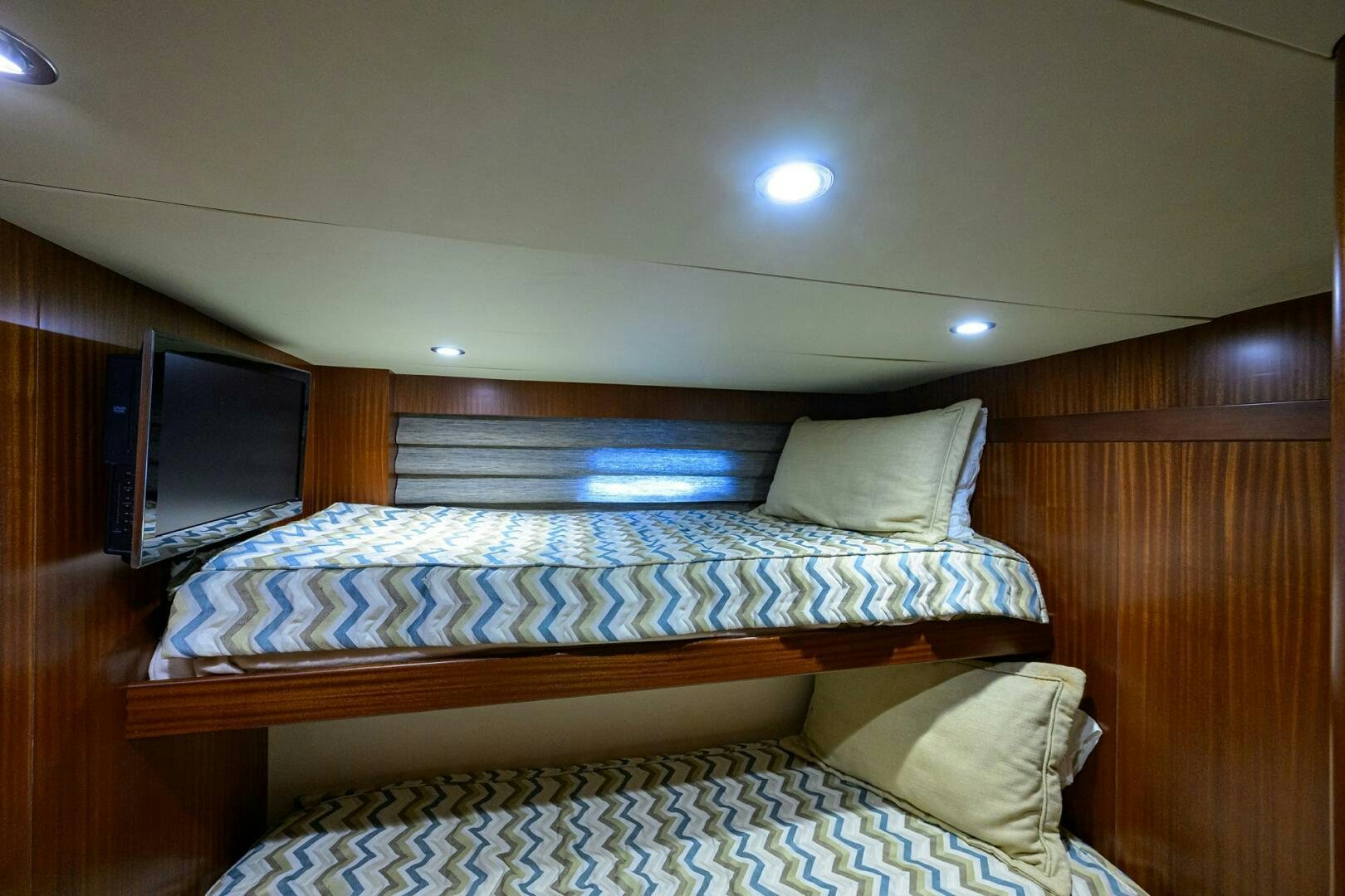 a bed with a television on the wall aboard JANE E Yacht for Sale