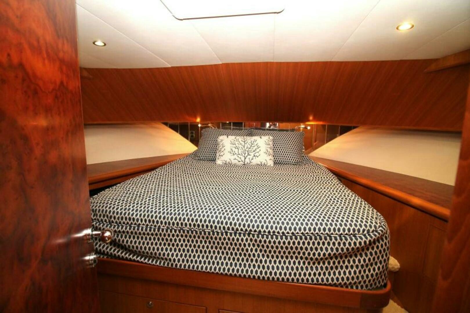 a bed with a wooden headboard aboard PARTNERSHIP Yacht for Sale