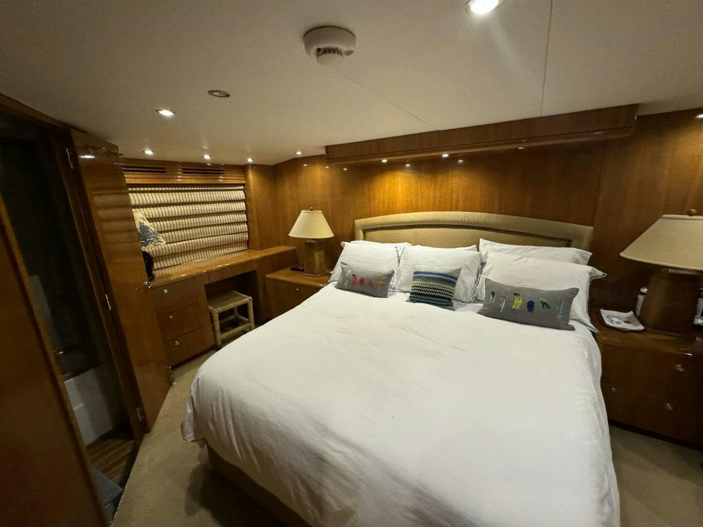 a bedroom with a bed and a wood cabinet aboard MRS. Z Yacht for Sale