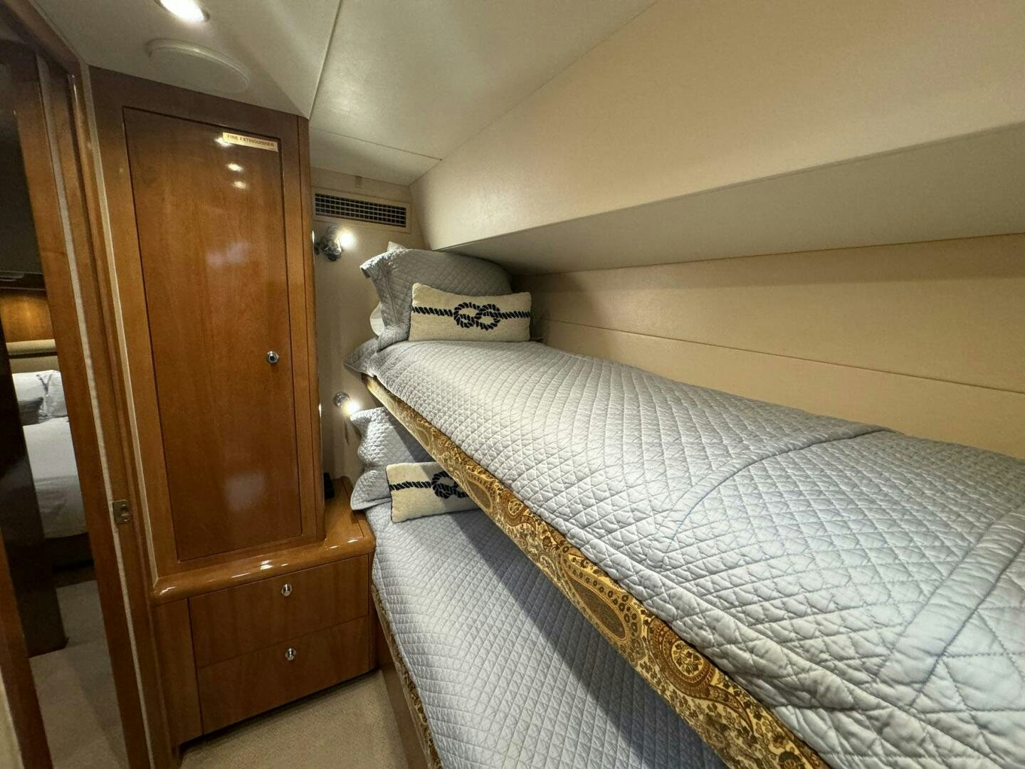 a bed with a blue and white comforter aboard MRS. Z Yacht for Sale