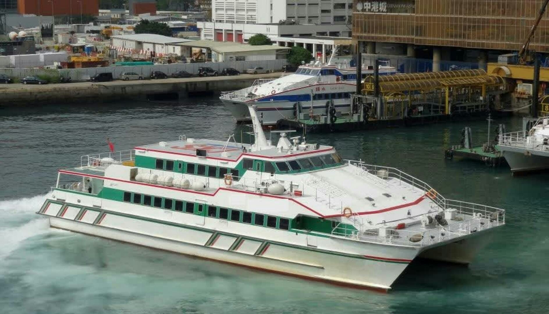a large white boat in a harbor aboard TING HONG Yacht for Sale