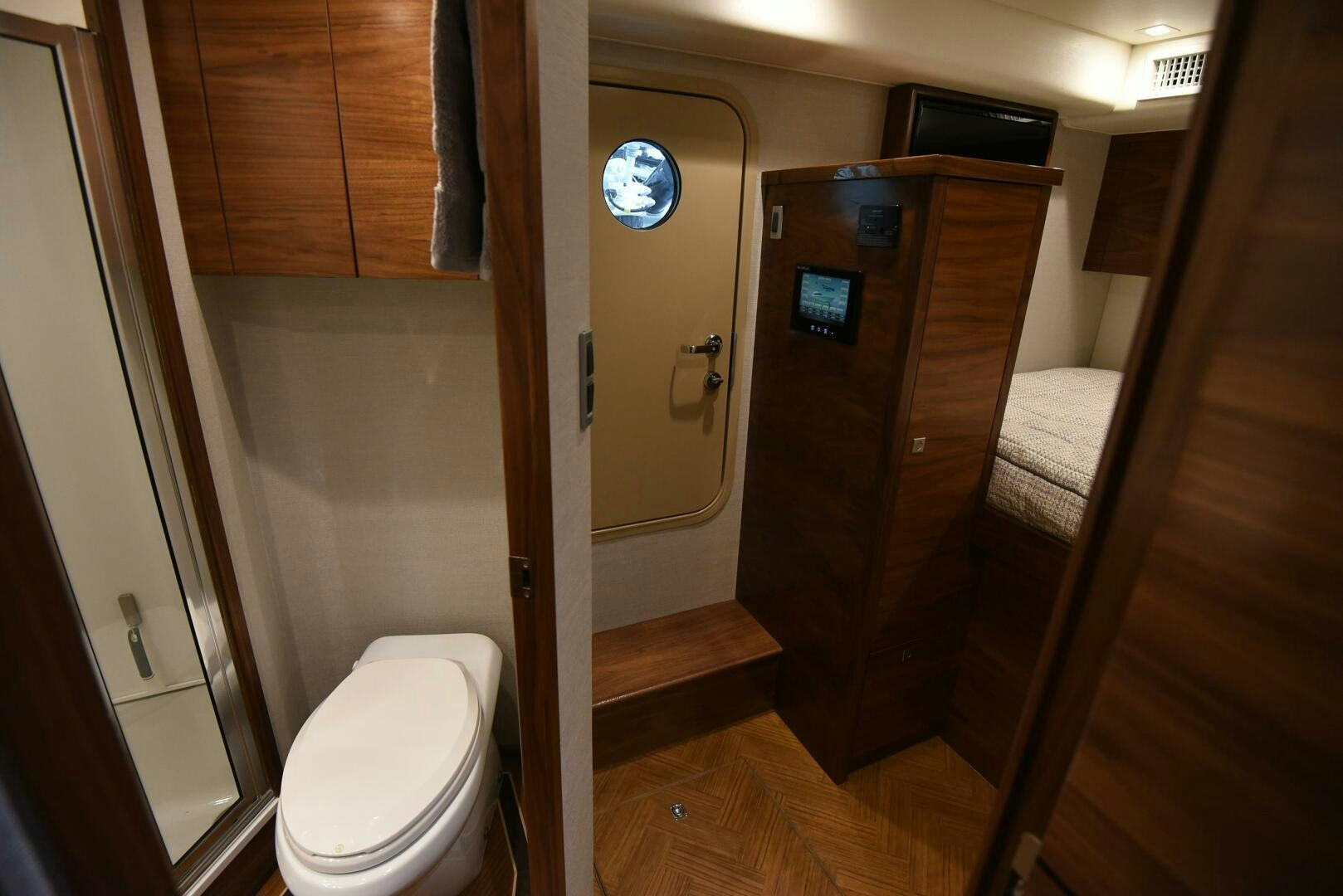 a bathroom with a toilet and a wood cabinet aboard AMANDA P Yacht for Sale