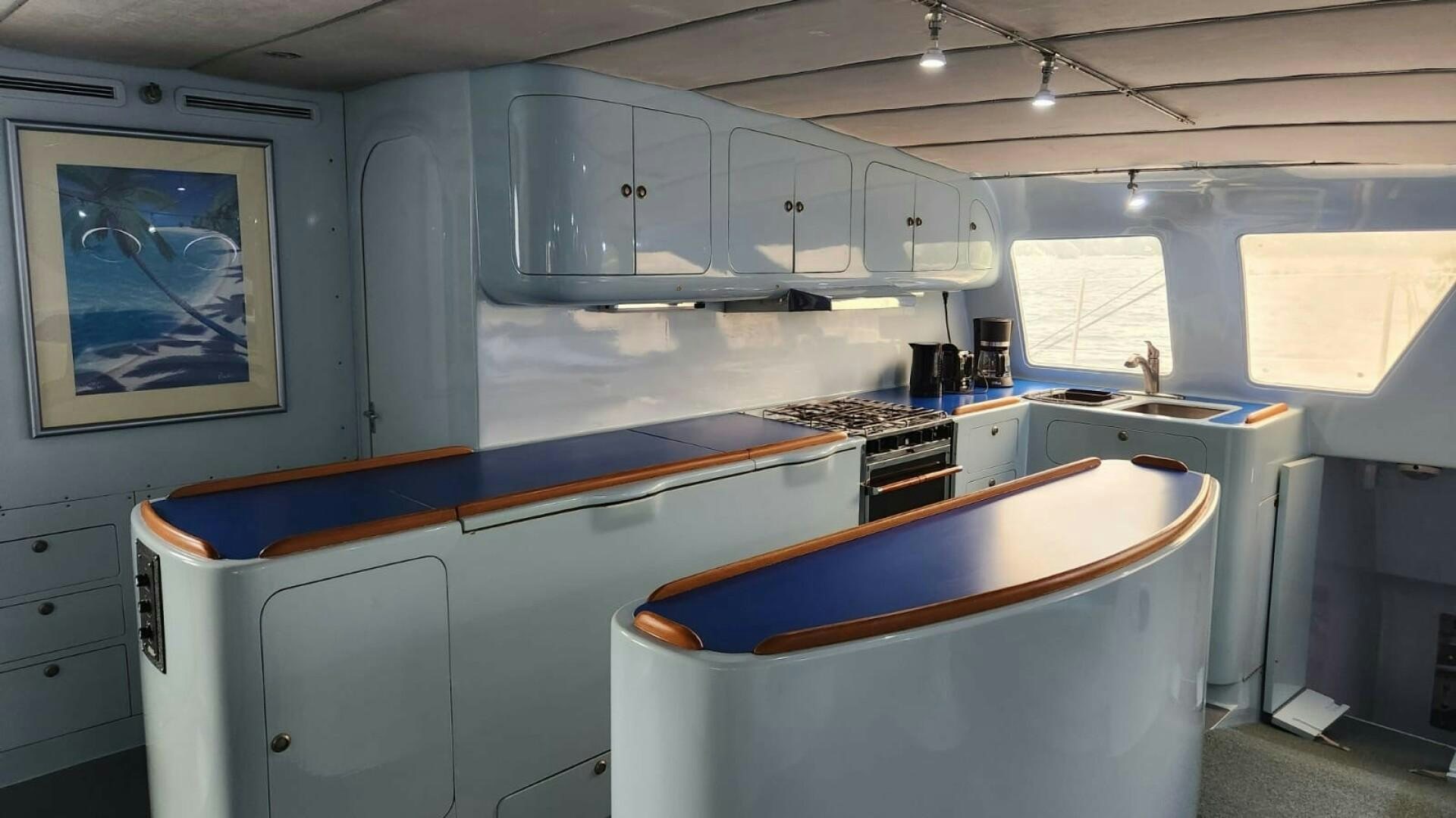 a kitchen with a painting on the wall aboard FAT CAT Yacht for Sale