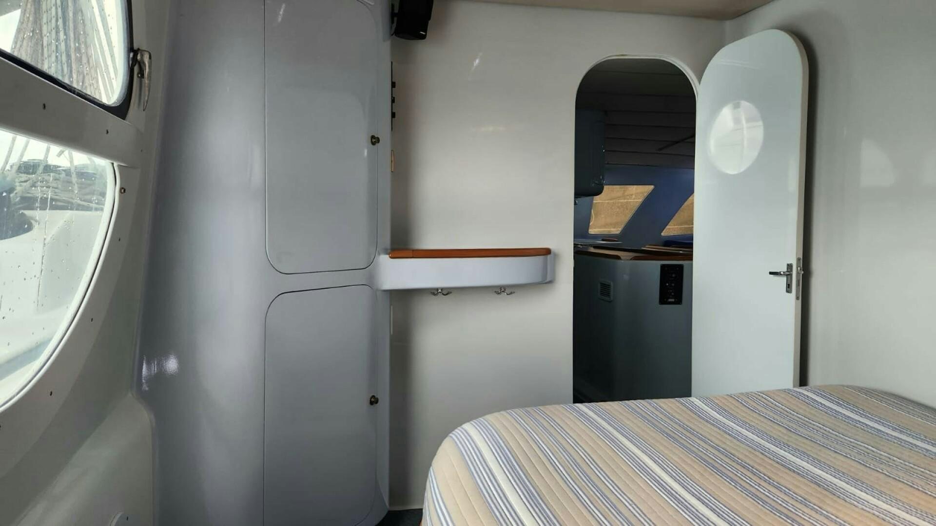 a bed and a desk in a room aboard FAT CAT Yacht for Sale