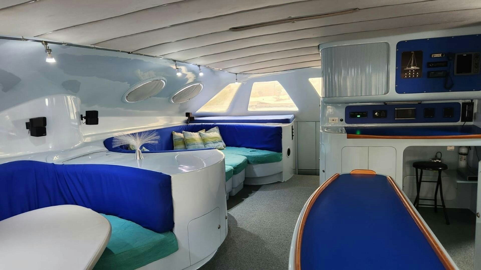 a room with beds and a blue chair aboard FAT CAT Yacht for Sale