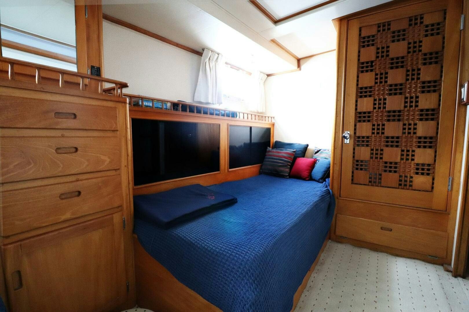 a bedroom with a bed and dresser aboard PIONEER Yacht for Sale
