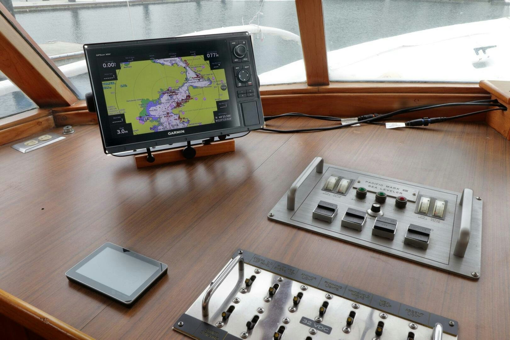 a computer and a phone on a table aboard PIONEER Yacht for Sale