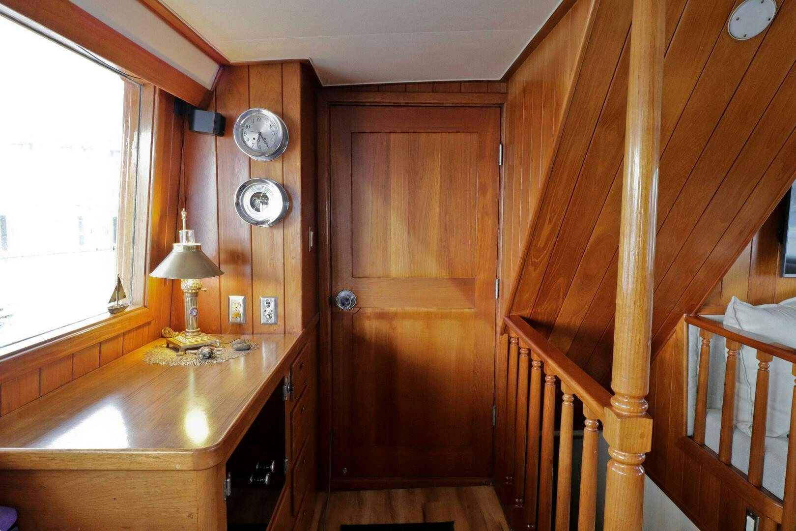 a wooden room with a table and a clock on the wall aboard PIONEER Yacht for Sale