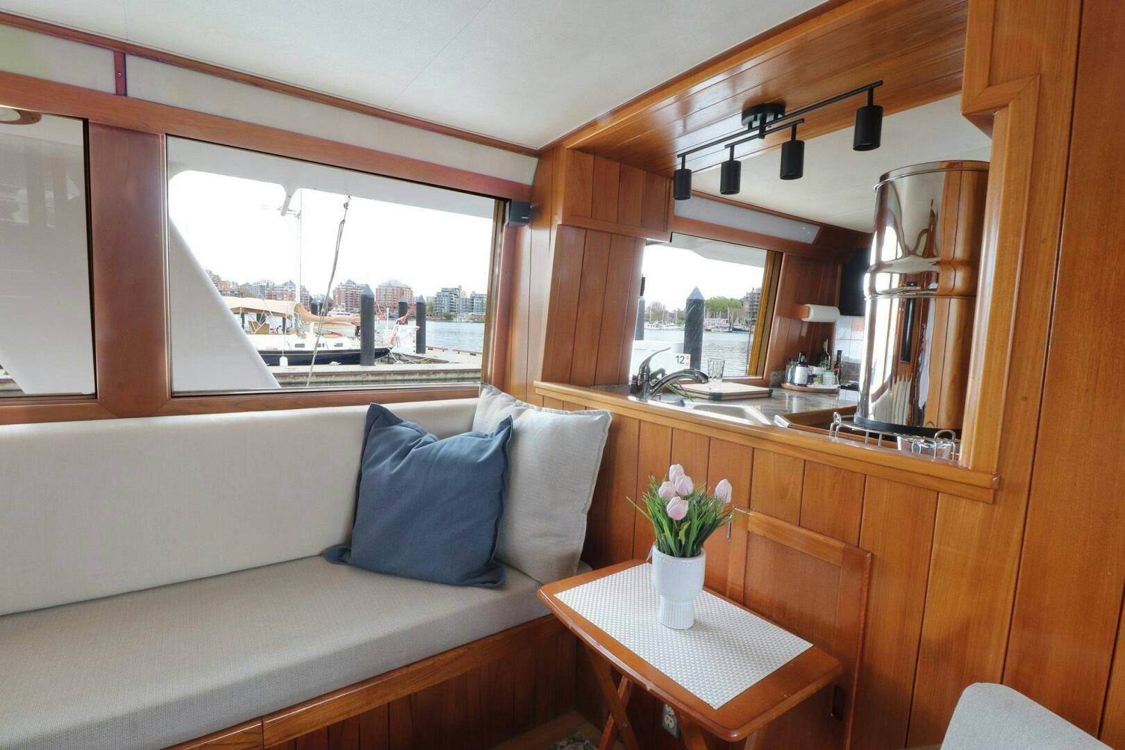 a room with a couch and a table with flowers in it aboard PIONEER Yacht for Sale