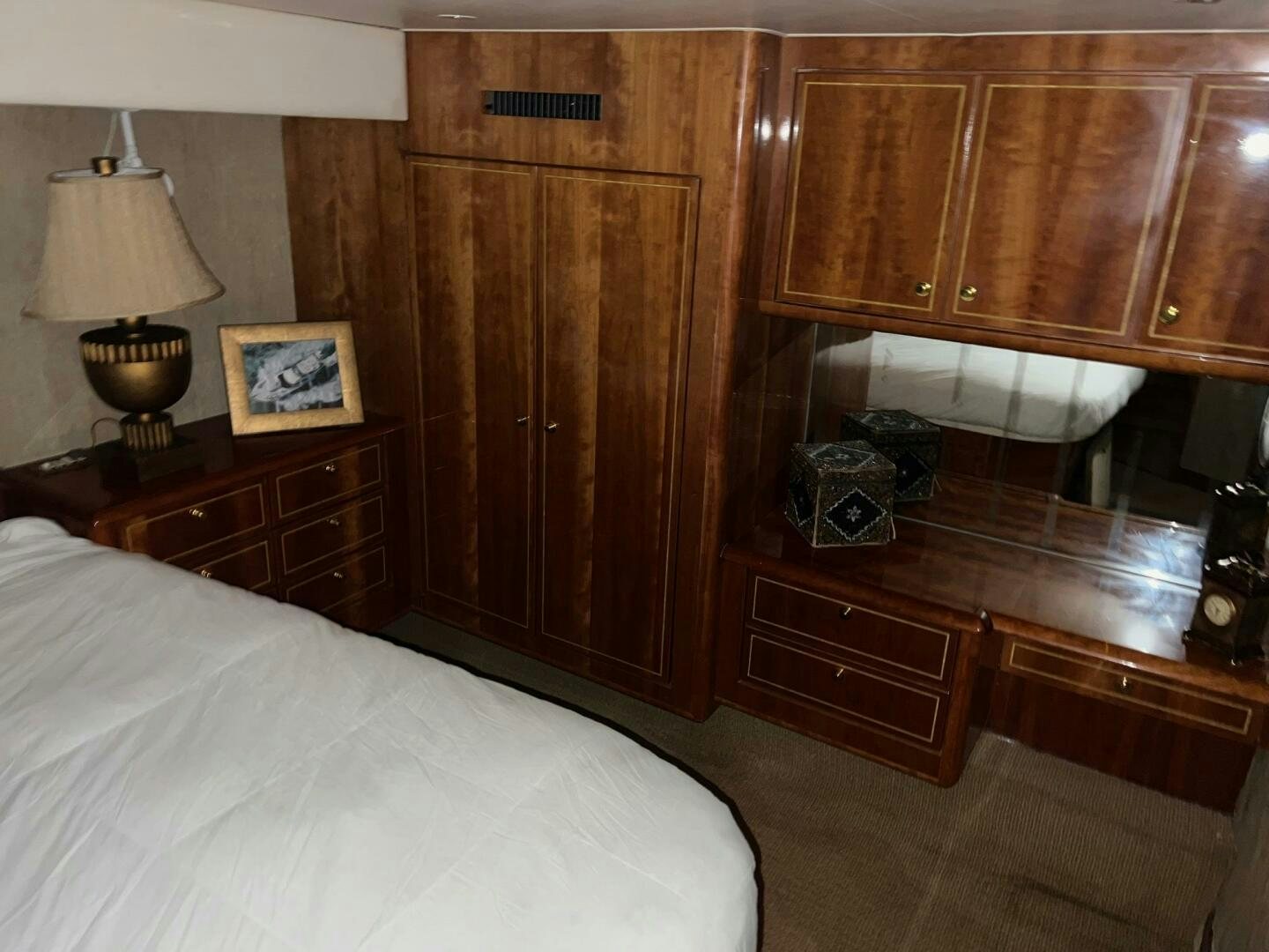 a bedroom with a bed and a wooden cabinet aboard BUCK-N-BILLS Yacht for Sale