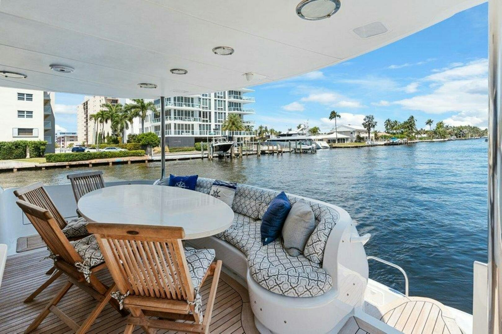 a table and chairs on a balcony overlooking a body of water aboard FOMO2 Yacht for Sale