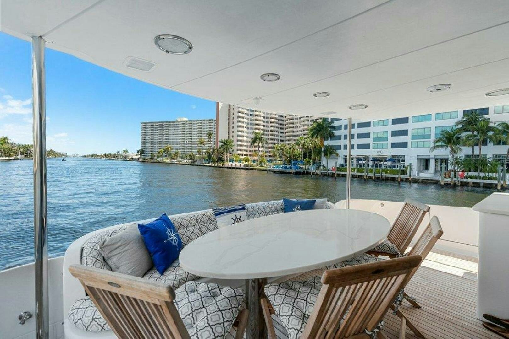 a table and chairs on a balcony overlooking a body of water aboard FOMO2 Yacht for Sale