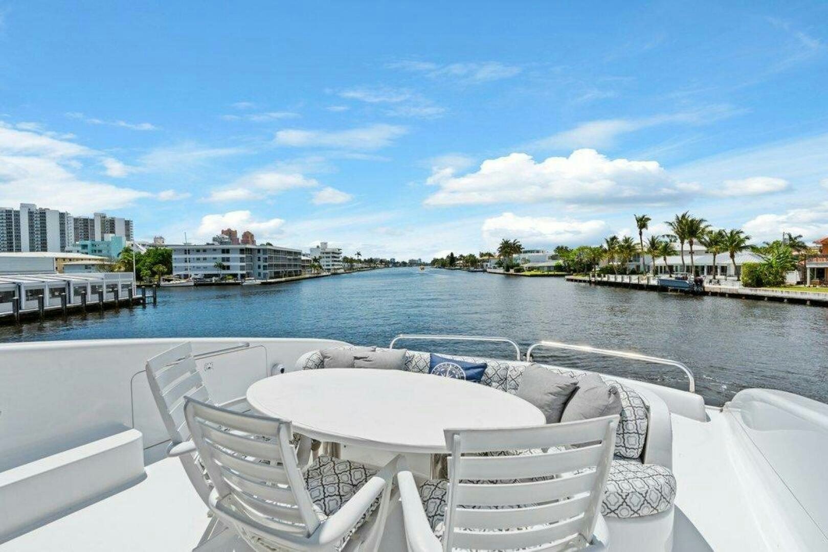 a group of chairs on a deck overlooking a body of water aboard FOMO2 Yacht for Sale
