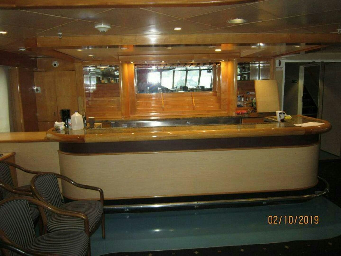 a room with a bar and chairs aboard AMERICANA Yacht for Sale