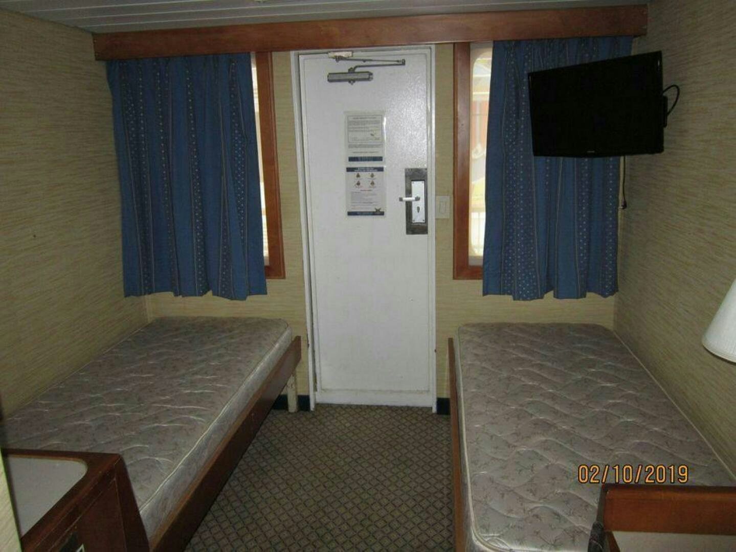 a room with a bed and a tv on the wall aboard AMERICANA Yacht for Sale