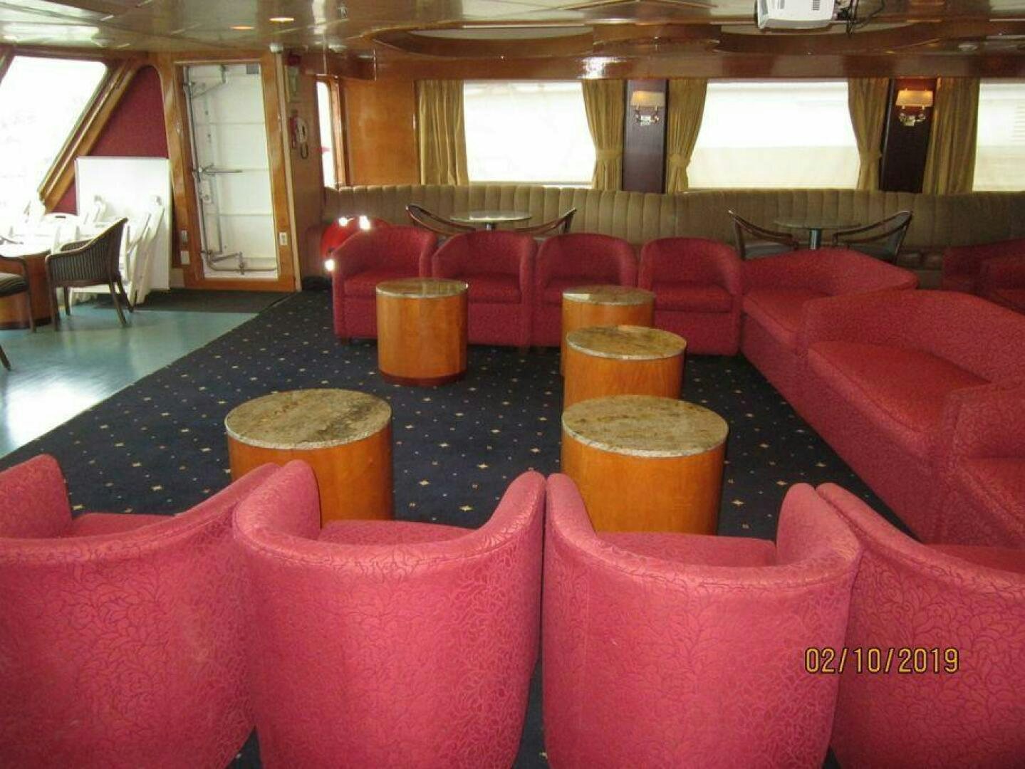 a room with red chairs and tables aboard AMERICANA Yacht for Sale