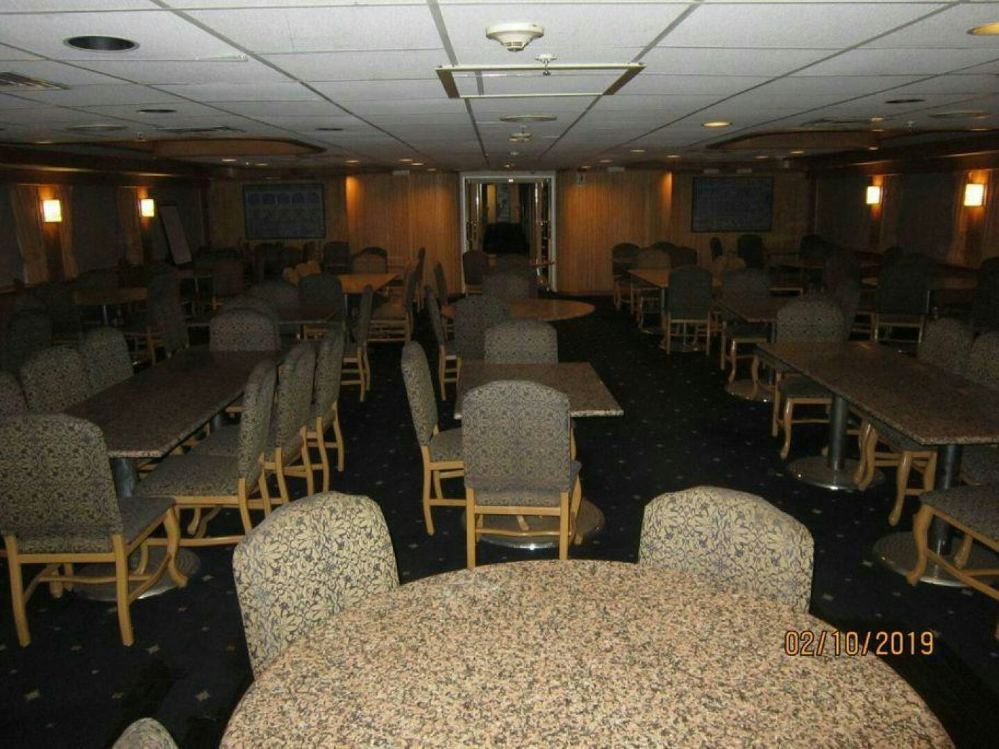 a room with tables and chairs aboard AMERICANA Yacht for Sale