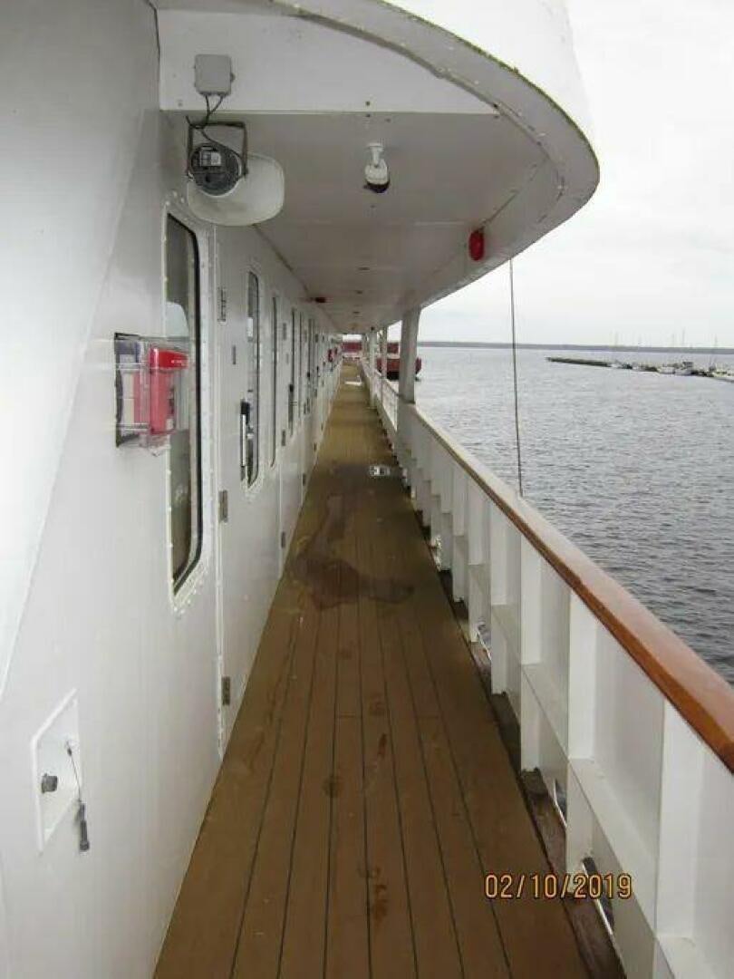 a long narrow wooden dock leading to a beach aboard AMERICANA Yacht for Sale