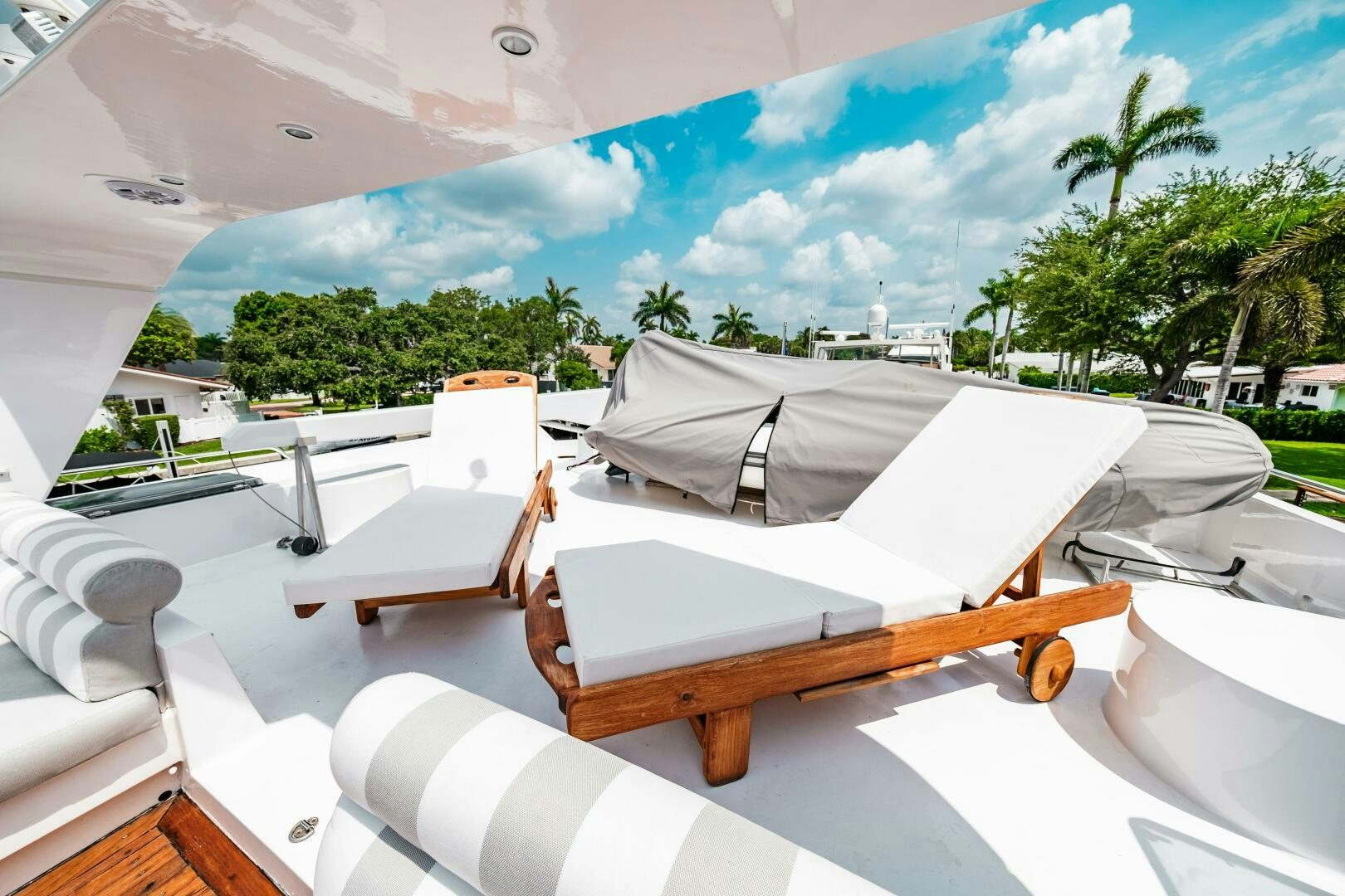 a deck with lounge chairs and trees aboard GLORIAS SUN Yacht for Sale