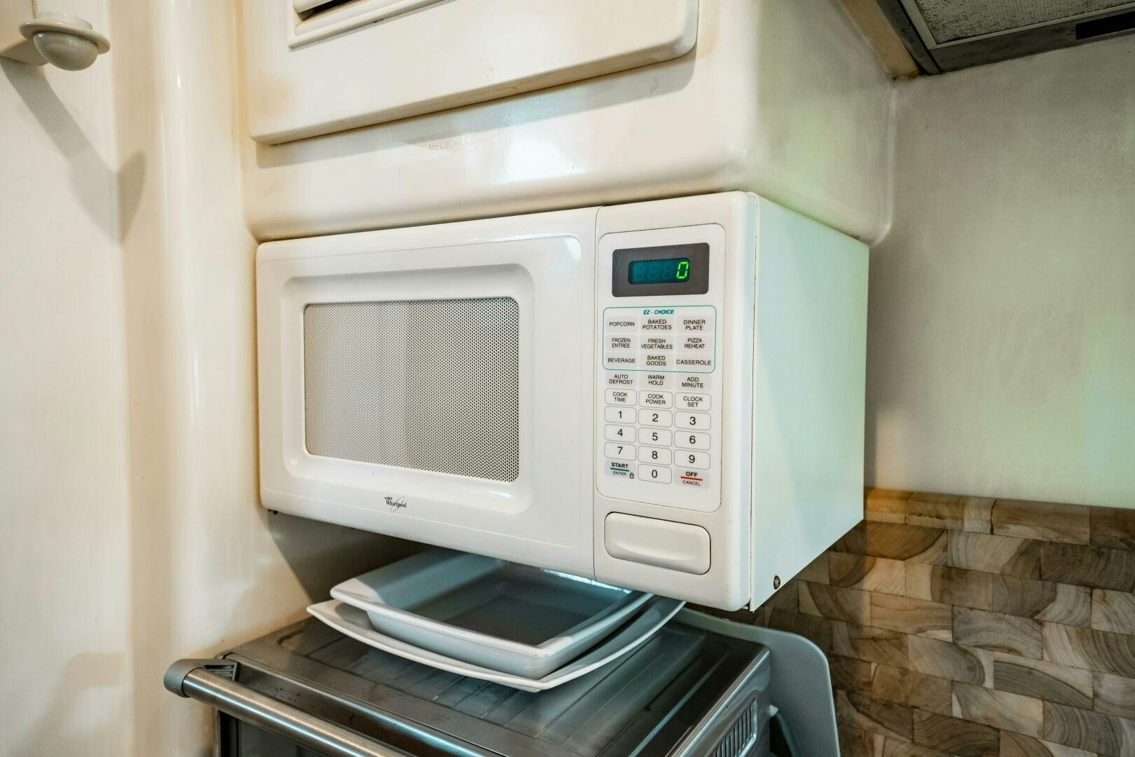 a microwave oven with a cell phone on top aboard GLORIAS SUN Yacht for Sale
