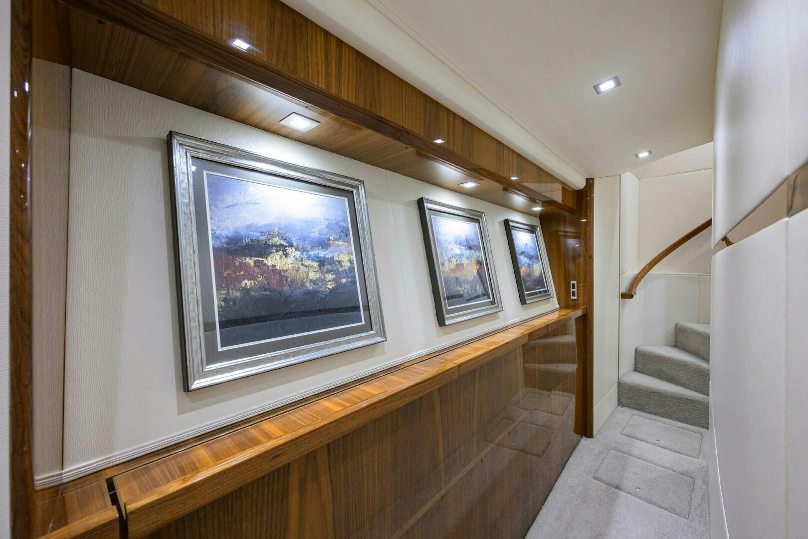 a wooden staircase with a painting on the wall aboard BACCHUS Yacht for Sale