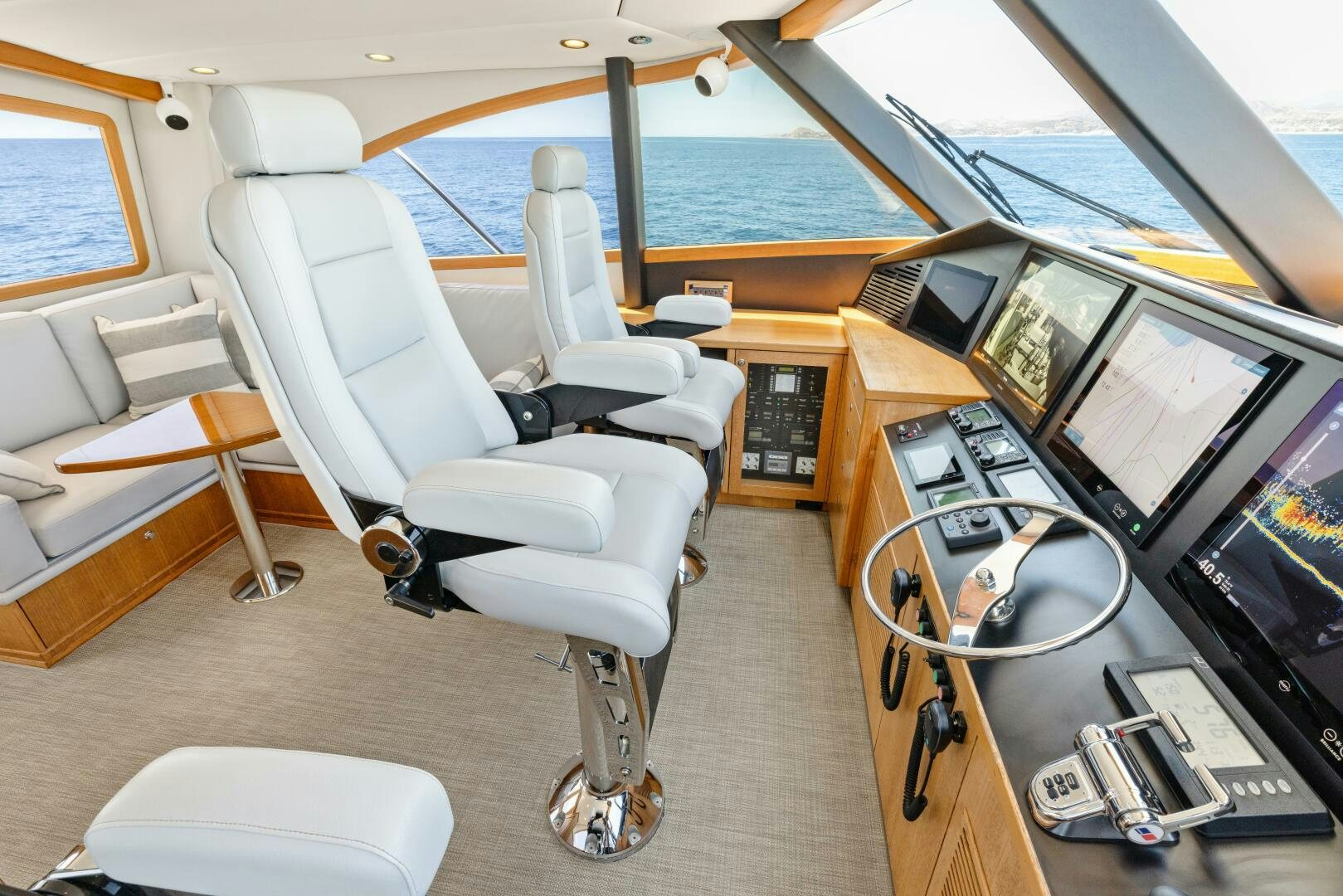 a room with a large window and a desk with computers and a large pool of water aboard SALTY K Yacht for Sale