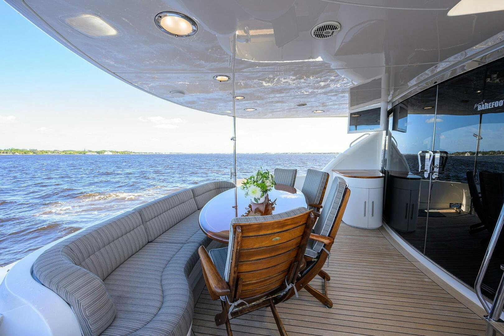 a deck with a table and chairs on it aboard ALWAYS BAREFOOT Yacht for Sale