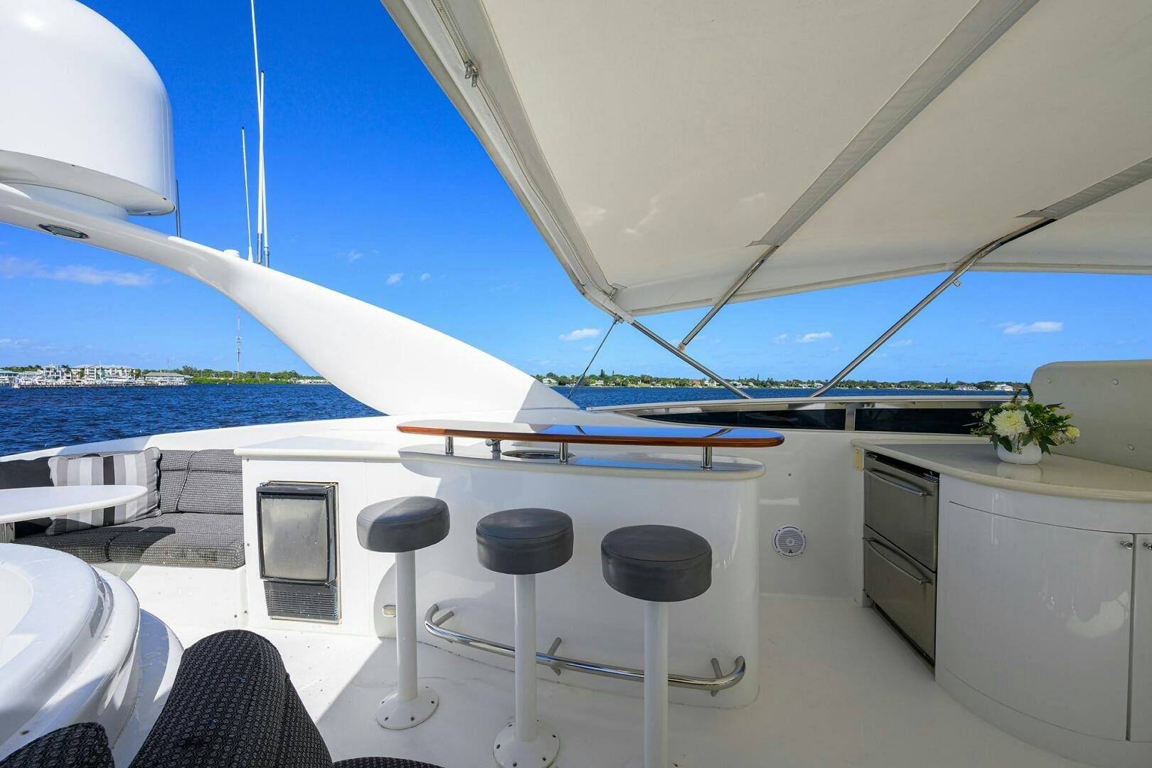 a boat with a bar and stools on the deck aboard ALWAYS BAREFOOT Yacht for Sale