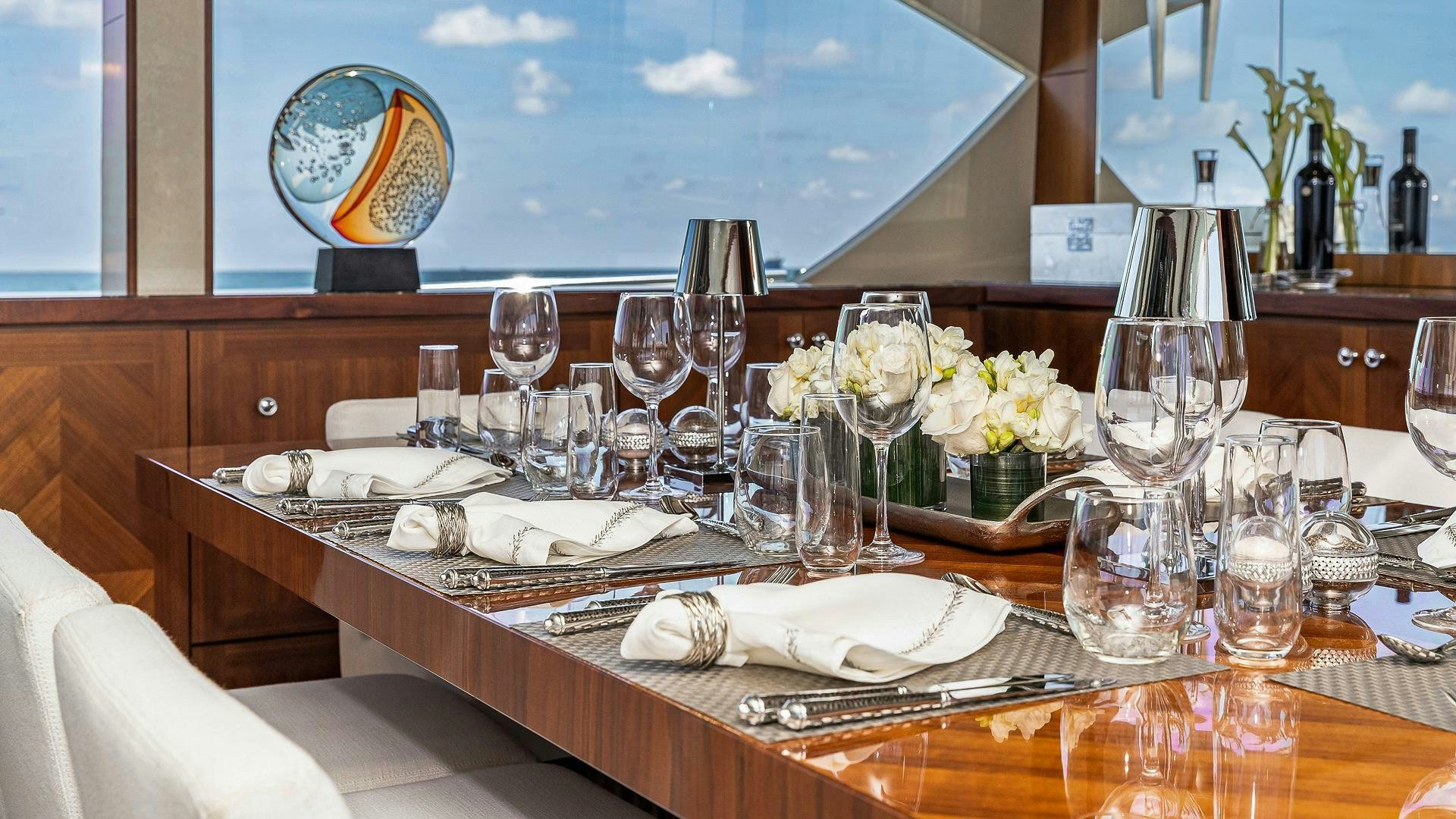 a table with wine glasses and flowers aboard NOW WE KNOW Yacht for Sale